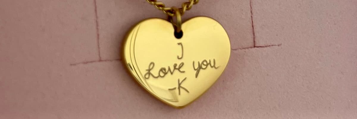 Gold heart pendant engraved with a handwritten message